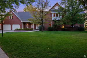 View of front of house featuring a garage and a yard