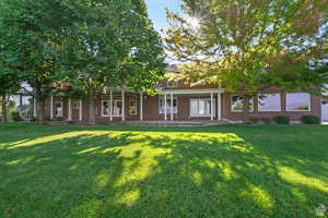 Rear view of house featuring a lawn