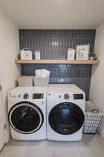 Laundry area with washer and clothes dryer and tile patterned floors