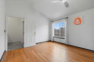 Empty room featuring light hardwood / wood-style flooring, vaulted ceiling, and ceiling fan