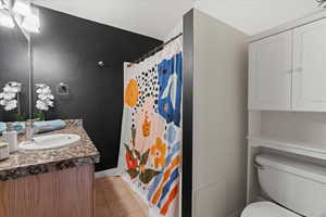 Bathroom featuring tile patterned floors, a shower with curtain, vanity, and toilet