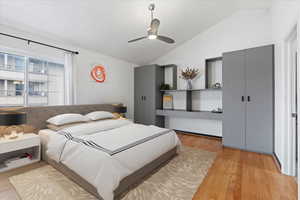 Bedroom with ceiling fan, light hardwood / wood-style flooring, and vaulted ceiling