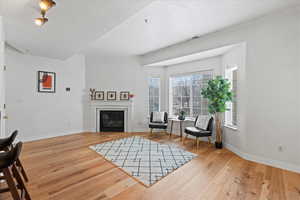 Living area with light wood-type flooring and ornamental molding