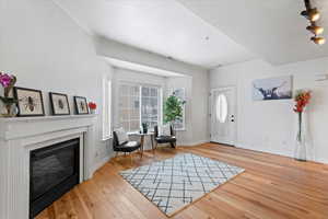 Foyer entrance featuring a tile fireplace, wood-type flooring, and crown molding