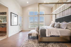 Bedroom featuring a mountain view, hardwood / wood-style flooring, and vaulted ceiling