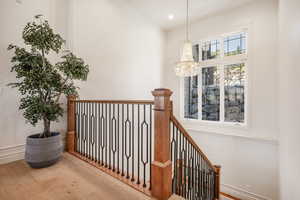 Corridor featuring hardwood / wood-style flooring and a notable chandelier