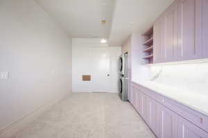 Kitchen with stacked washer / dryer and light stone countertops