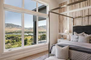 Bedroom featuring hardwood / wood-style floors and a water and mountain view