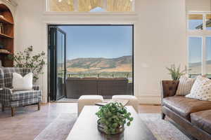 Living room featuring a mountain view, a towering ceiling, and wood-type flooring