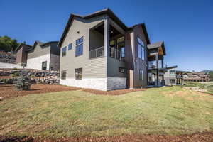 View of home's exterior featuring a balcony and a yard