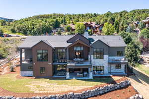 Back of house with a patio, a balcony, and a lawn