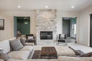 Living room featuring carpet and a stone fireplace