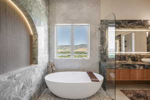 Bathroom featuring a bathing tub, vanity, a mountain view, and tile walls