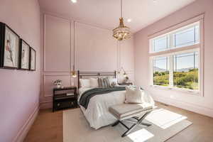 Bedroom featuring light hardwood / wood-style flooring and a notable chandelier