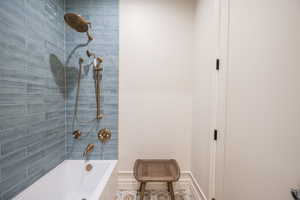 Bathroom with tile patterned floors and tiled shower / bath combo