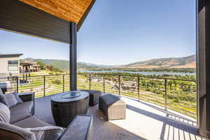 Balcony featuring a water and mountain view