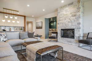 Carpeted living room with a stone fireplace