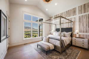 Bedroom with a mountain view, hardwood / wood-style flooring, and high vaulted ceiling