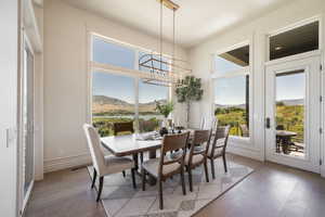 Dining room featuring a chandelier, light wood-type flooring, and a water and mountain view