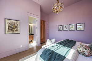 Bedroom featuring light hardwood / wood-style floors and a notable chandelier