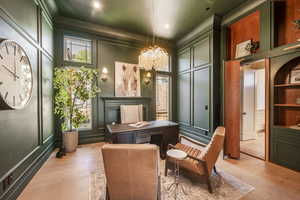 Living area featuring built in shelves, light hardwood / wood-style flooring, an inviting chandelier, and ornamental molding