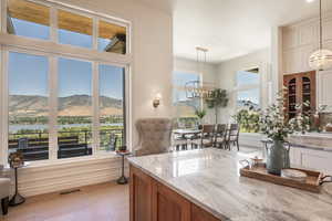 Kitchen featuring light stone countertops, light wood-type flooring, a notable chandelier, hanging light fixtures, and a water and mountain view