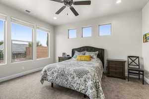 Carpeted bedroom featuring ceiling fan