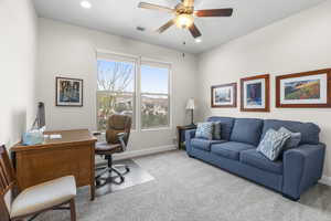 Home office with ceiling fan and carpet floors