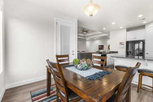 Dining room with a raised ceiling, ceiling fan, dark hardwood / wood-style flooring, and sink