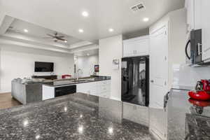 Kitchen featuring black appliances, sink, white cabinetry, and kitchen peninsula