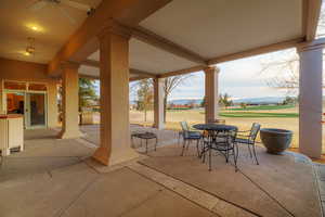 View of patio featuring a mountain view and golf course