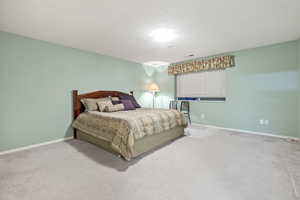 second photo of Bedroom featuring carpet and a textured ceiling