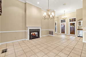 formal dining room featuring a fireplace, an inviting chandelier, light tile patterned flooring, and ornamental molding