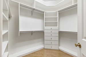 Walk in closet featuring light wood-type flooring (primary bathroom)