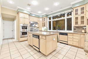 Kitchen with a center island with sink, two dishwashers, stainless steel double oven, and backsplash