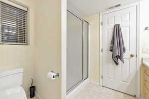 Bathroom with vanity, toilet, a textured ceiling, and walk in shower