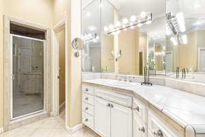 Second primary bathroom featuring tile patterned flooring, vanity, a tiled shower with door, and crown molding