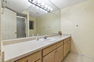 Bathroom featuring a shower with door, vanity, and toilet