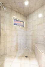 tiled shower located in second primary bathroom