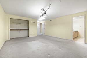 Unfurnished bedroom featuring light colored carpet and ensuite bath