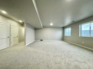 Basement featuring light colored carpet