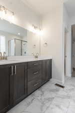 Bathroom featuring a shower with door and vanity