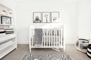 Carpeted bedroom featuring a crib