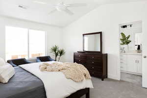 Bedroom with ensuite bath, ceiling fan, sink, vaulted ceiling, and light carpet