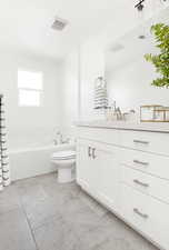 Bathroom with vanity, a bathtub, and toilet