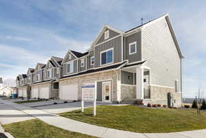 Townhome / multi-family property featuring a front yard and a garage