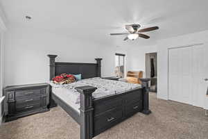 Carpeted bedroom with ceiling fan and ornamental molding