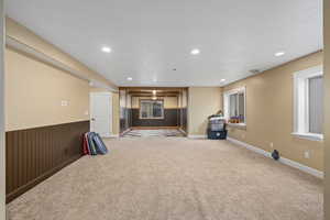 Unfurnished living room with carpet flooring and wooden walls