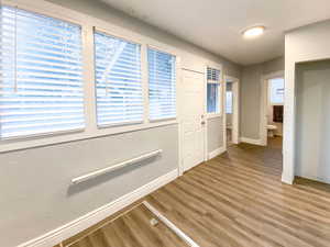 Back hall with new windows, new blinds, new flooring, and a door providing easy access to the backyard