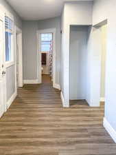 Back hall with new paint and new wood laminate flooring, leading toward the bathroom